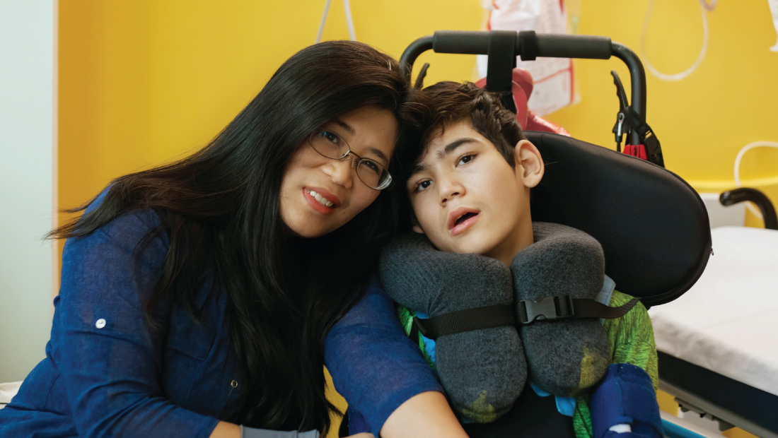 asian mother and special needs son together in hospital room